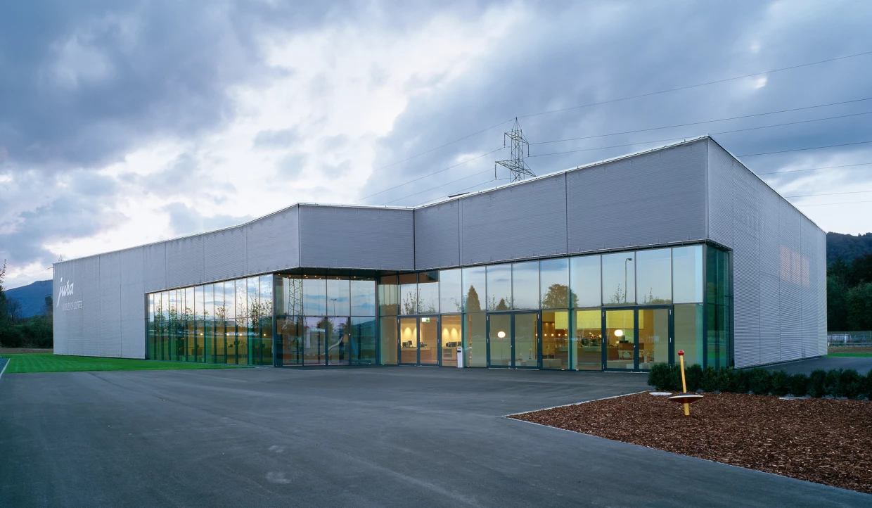 Gebäudekomplex mit Glasfronten unter bewölktem Himmel