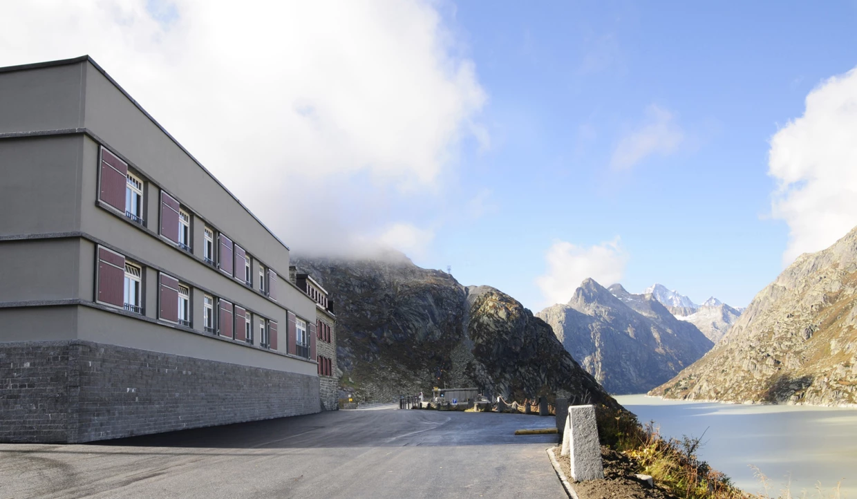 Modern building view next to a lake with mountains in the background