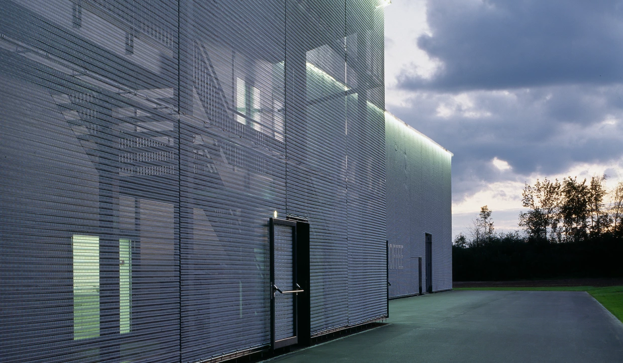 Seitenansicht eines Gebäudes mit Metallverkleidung bei bewölktem Himmel