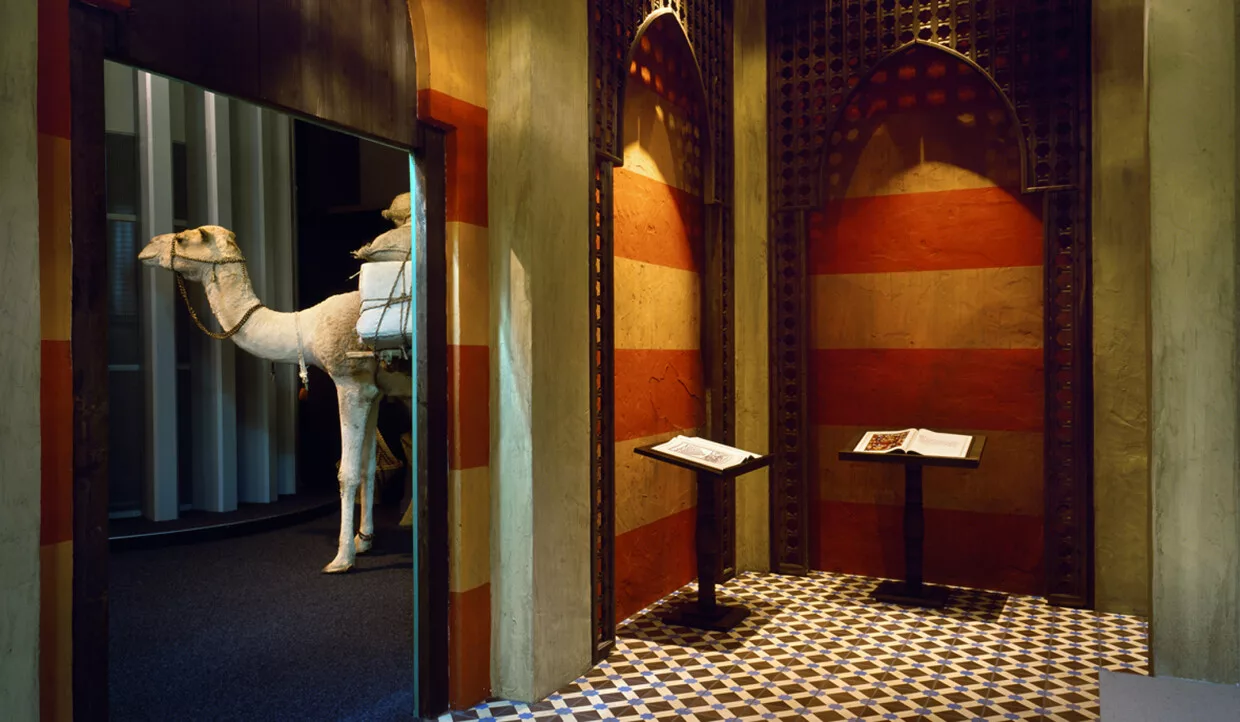 Ausstellung mit Kamelmodell und arabischem Architekturmotiv