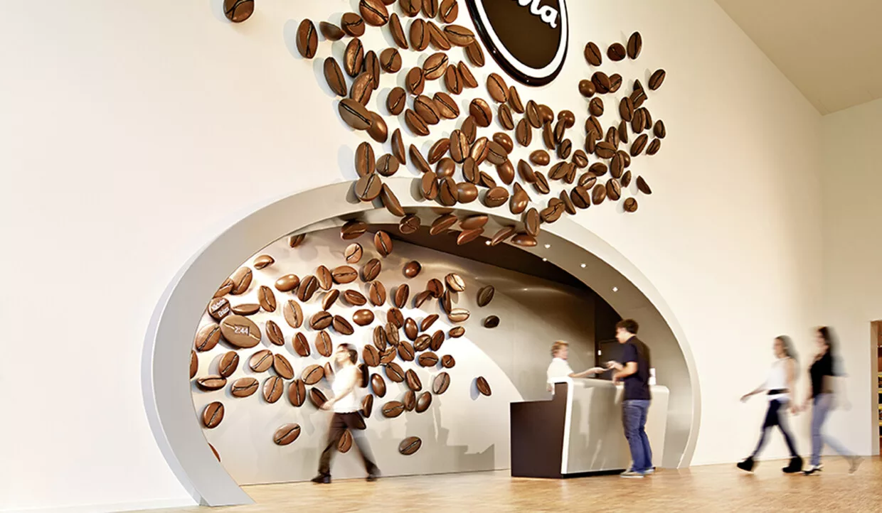 Ausstellungsbereich mit fliegenden Kaffeebohnen an der Wand