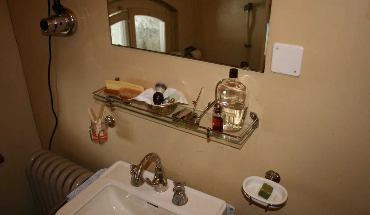 Bathroom with mirror, sink, and shelf