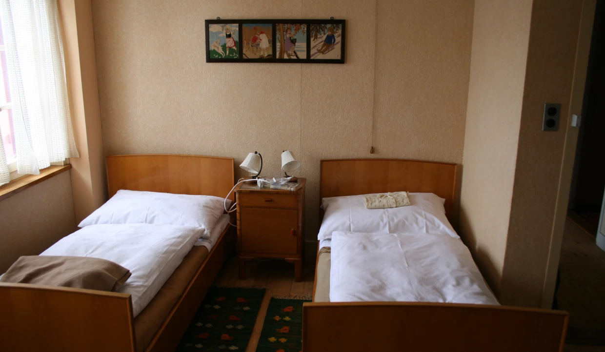 Two single beds with nightstand and reading lamps