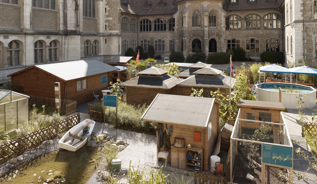 Holzhütten und Pool im Innenhof eines historischen Gebäudes