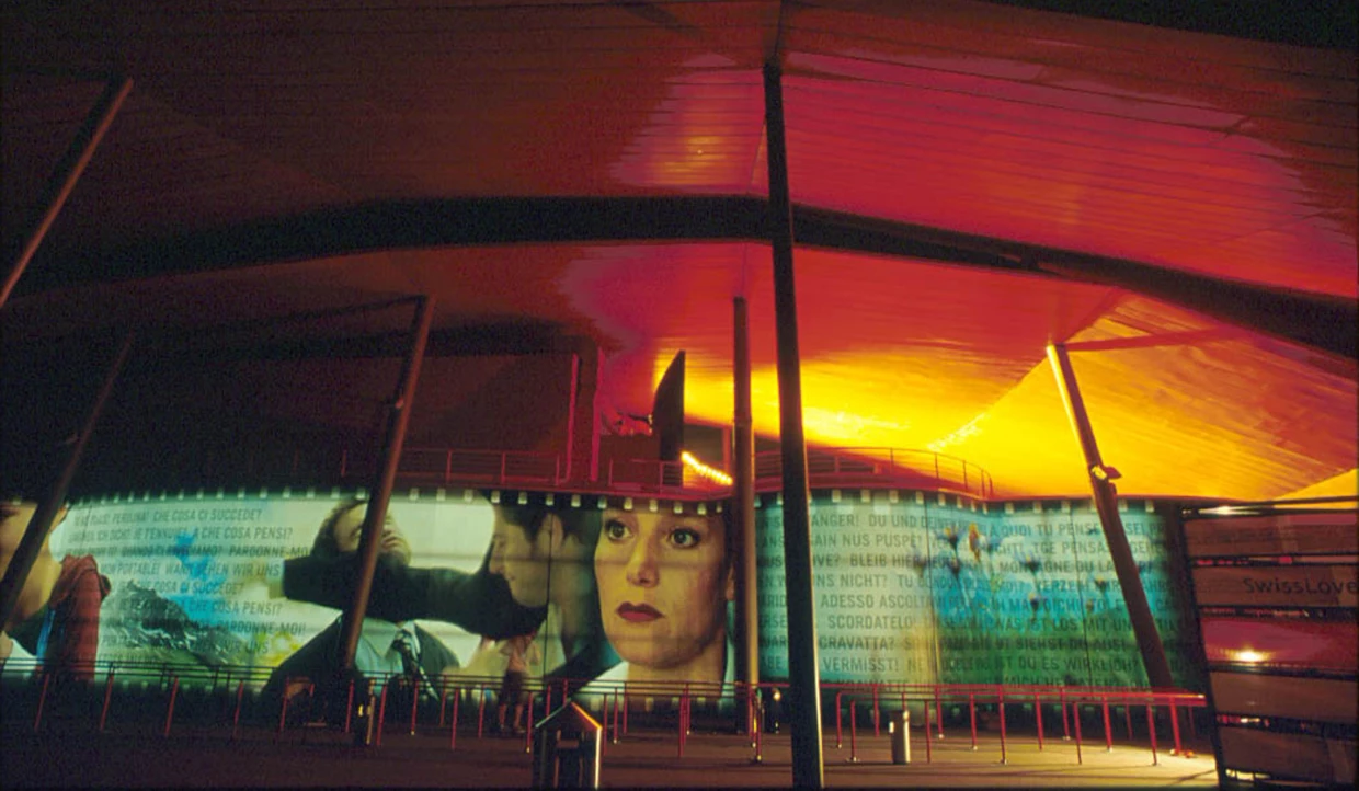 Modern facade with colorful light projections and faces