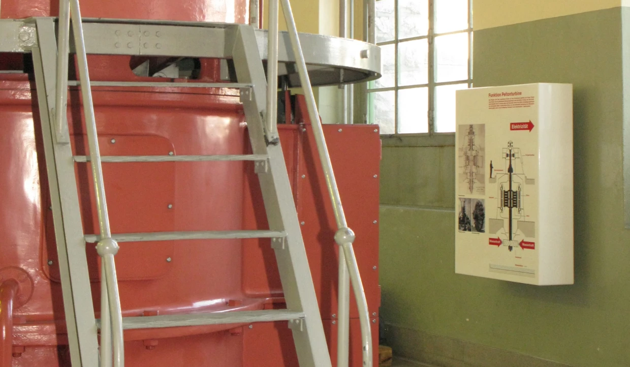 Red machinery parts with gray ladder and wall panel