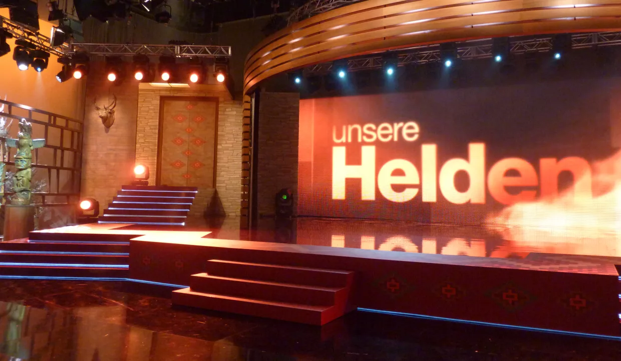 Bühne mit beleuchtetem Schriftzug 'unsere Helden'