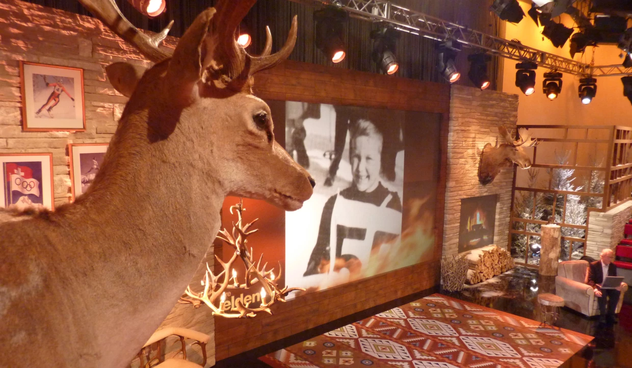 Stage with deer head, picture frames, and old photo