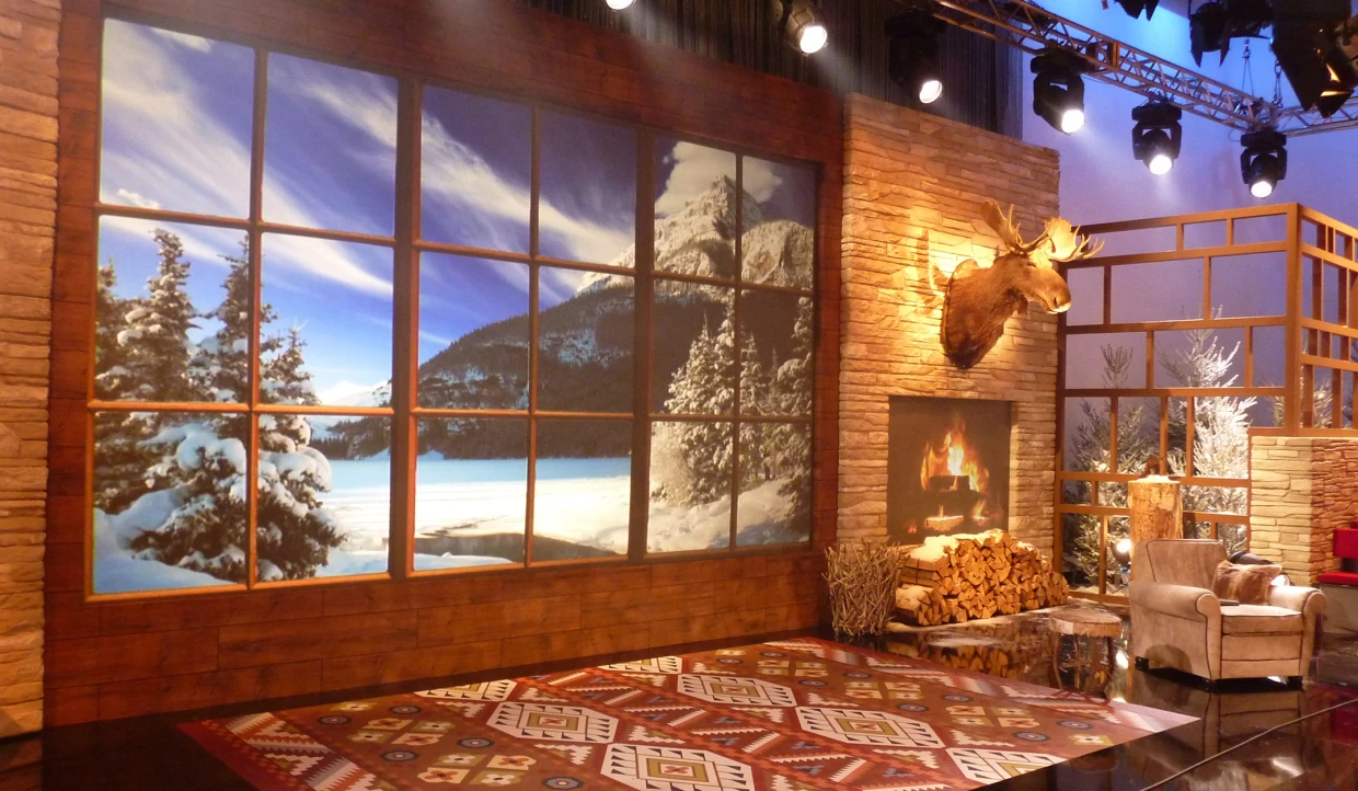 Stage with fireplace, moose head, and large window with winter landscape