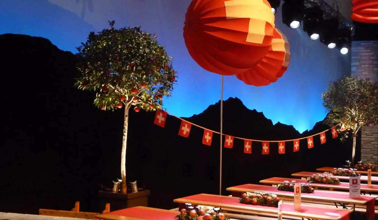 Stage with red lanterns, Swiss flags, and tree