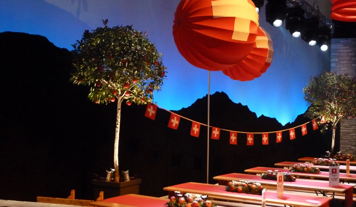 Stage with red lanterns, Swiss flags, and tree