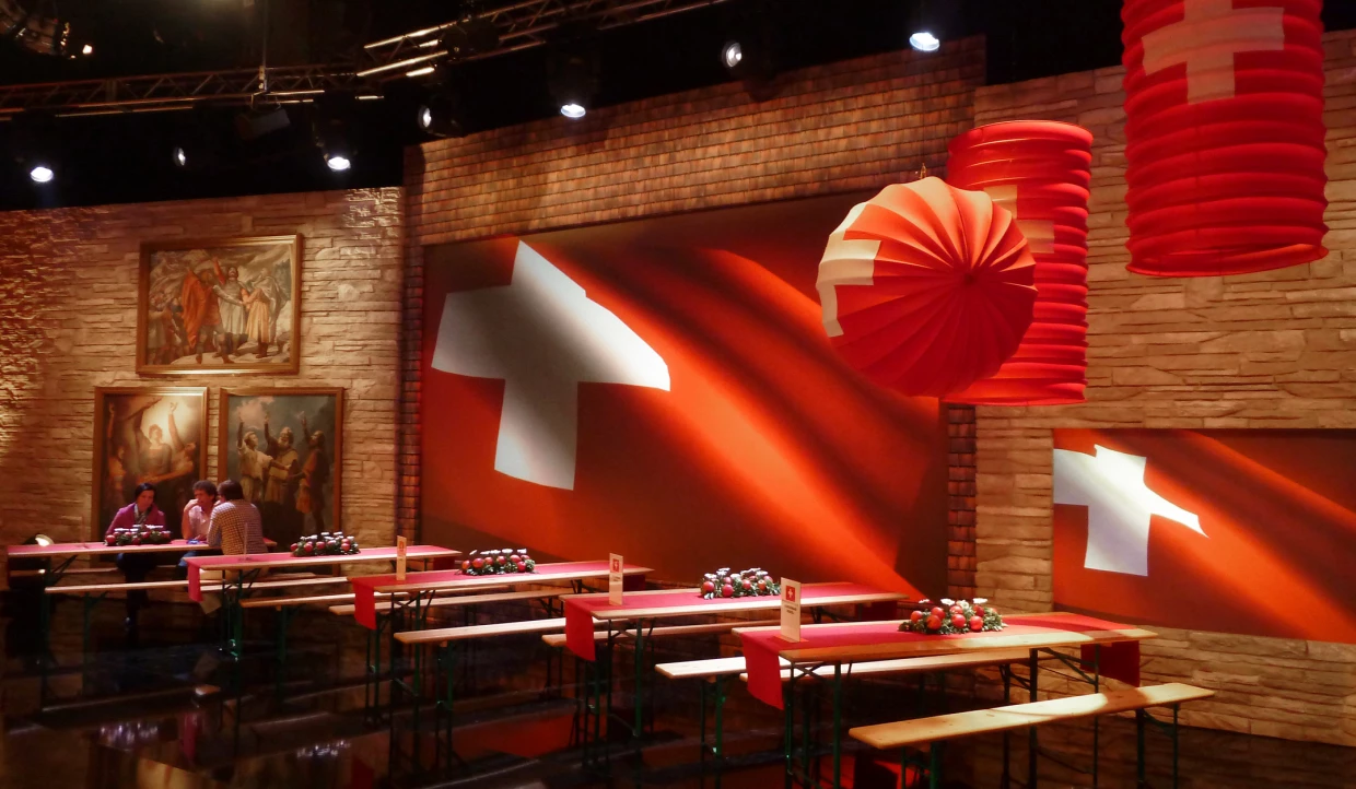 Stage with Swiss flag, red light, and paintings
