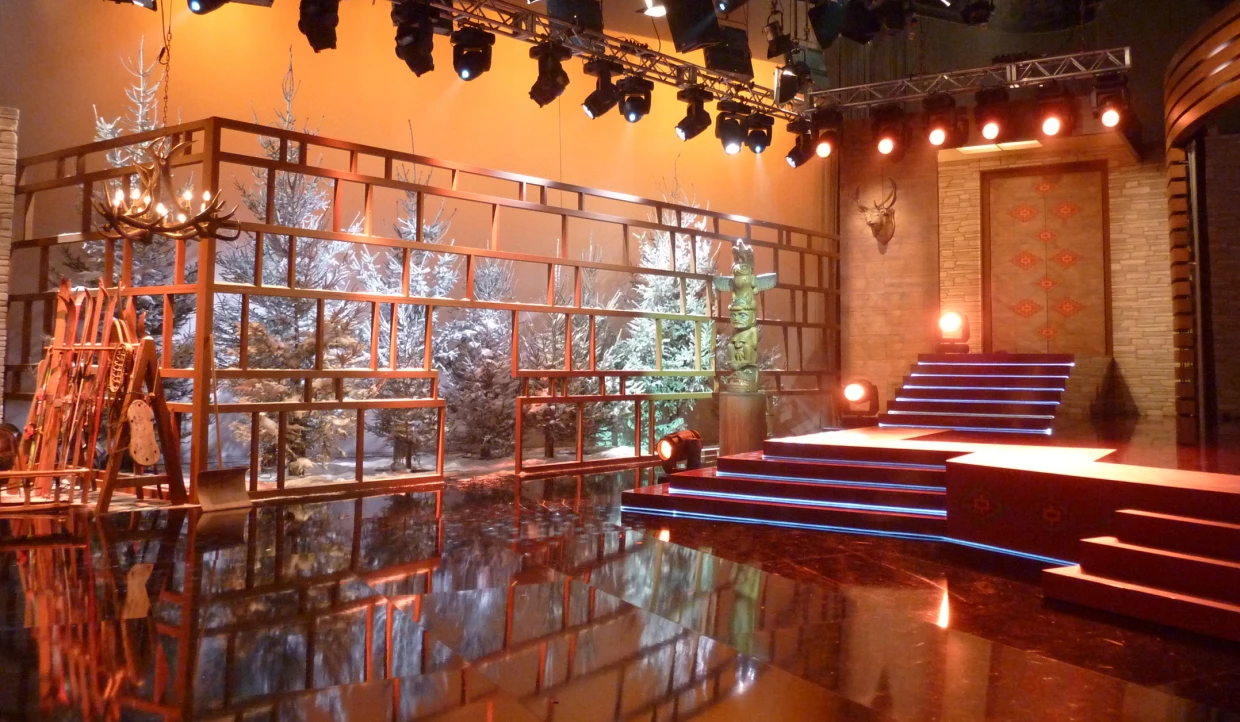 Stage with pine trees, totem pole, and skis