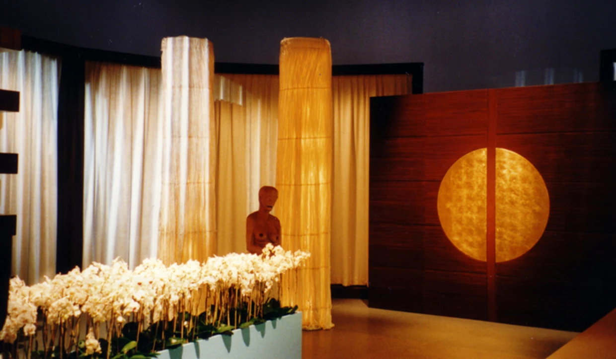 Stage set with white flowers, wooden columns and circular light elements