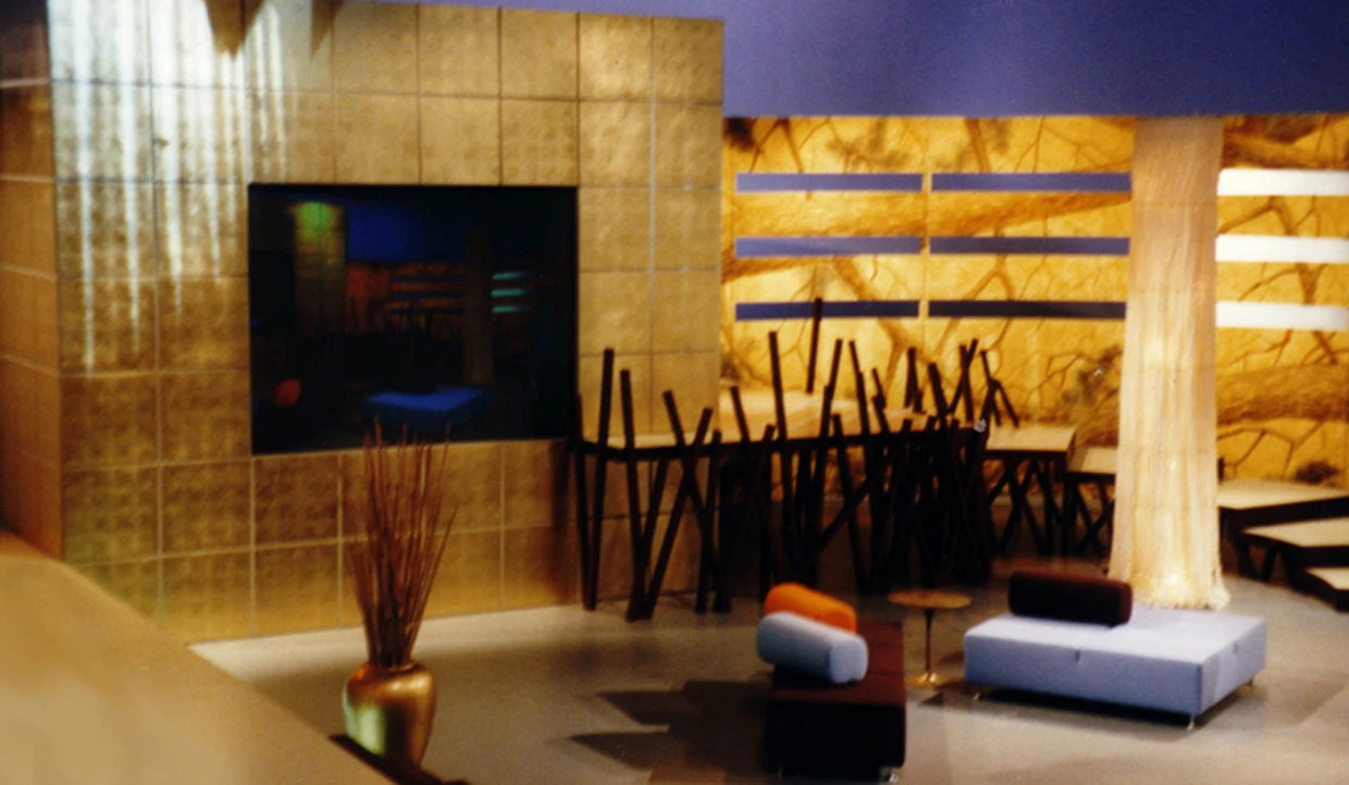 Stage set with golden wall, sofa and stylized wooden elements