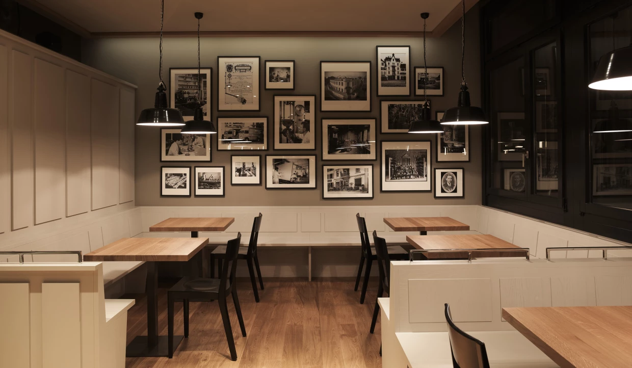 Ecke im Restaurant mit Fotowand und kleinen Holztischen.