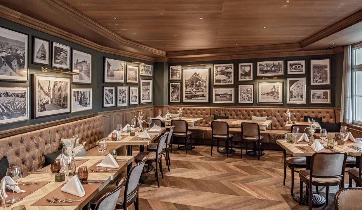 Elegantes Restaurant mit Holzmöbeln und Wänden voller Schwarz-Weiß-Fotografien