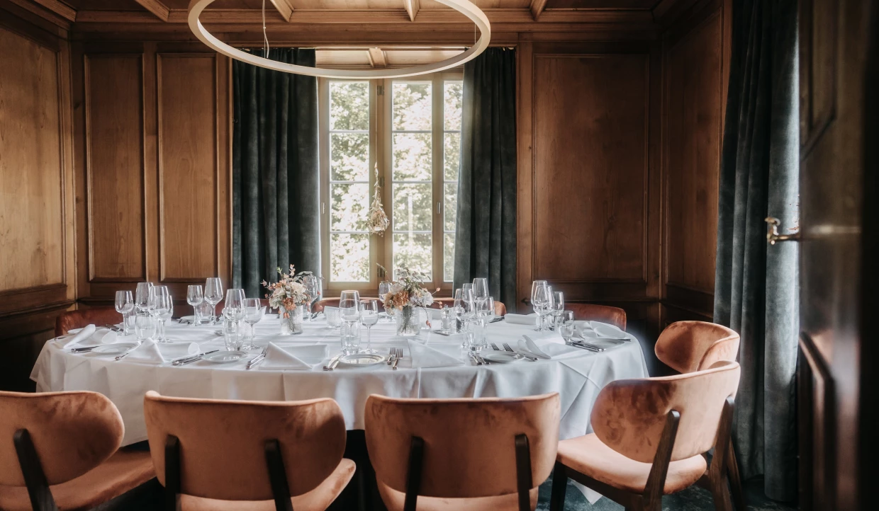 Private room in a country restaurant with a round table and wooden walls
