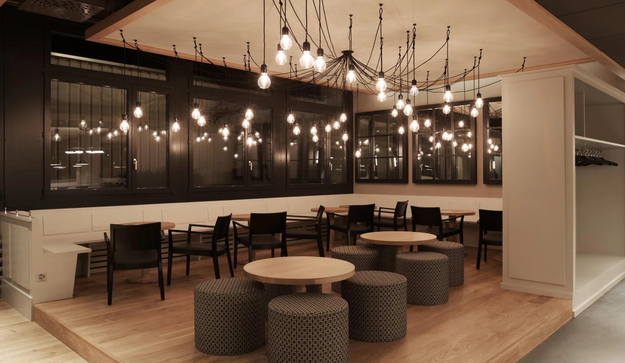 Gemütliche Ecke im Restaurant mit runden Tischen und Lichterketten.