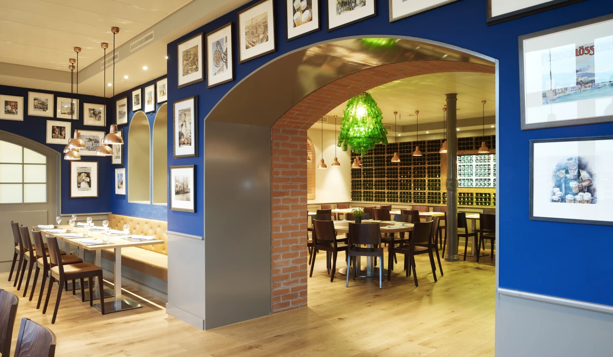 Dining area with blue wall and pictures, visible archways.