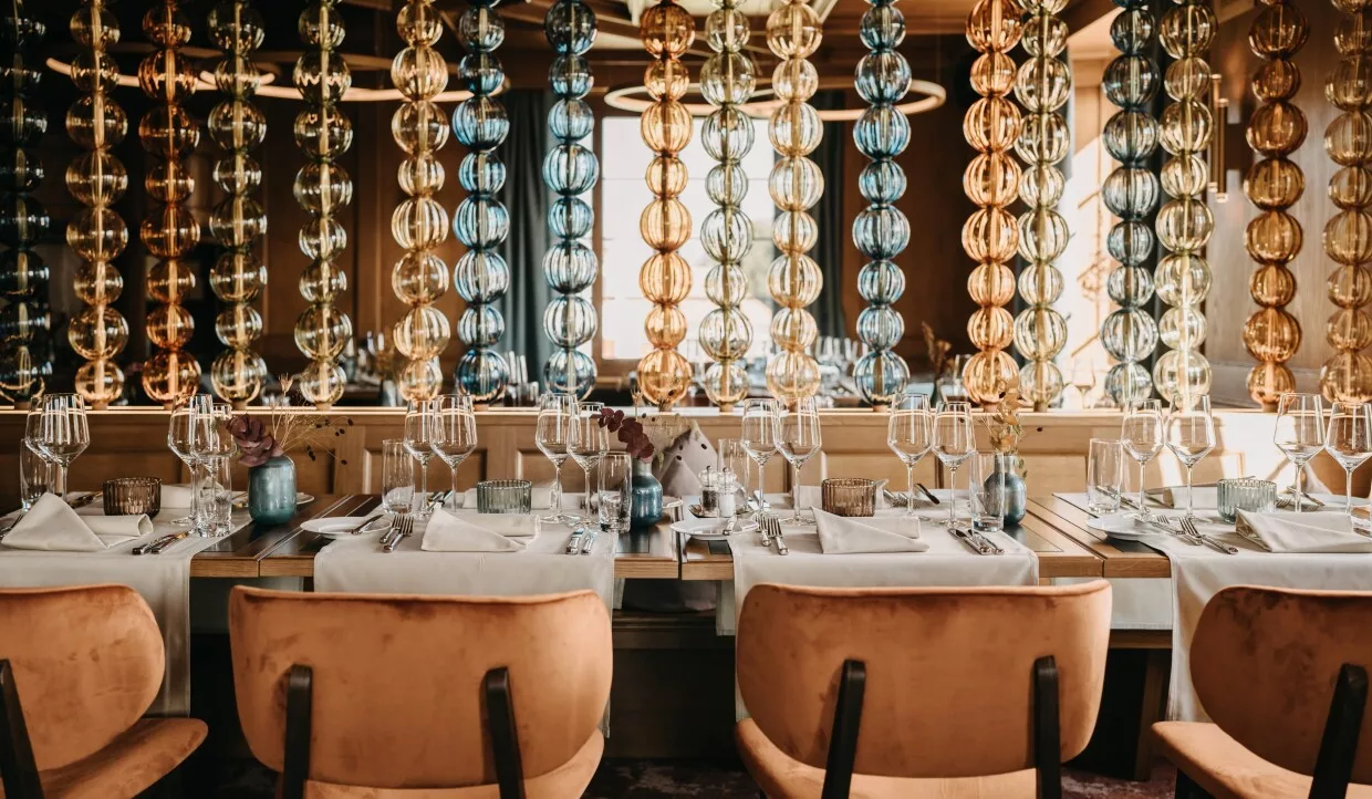 Restaurant-Innenraum mit bunten Glasketten und gedecktem Tisch
