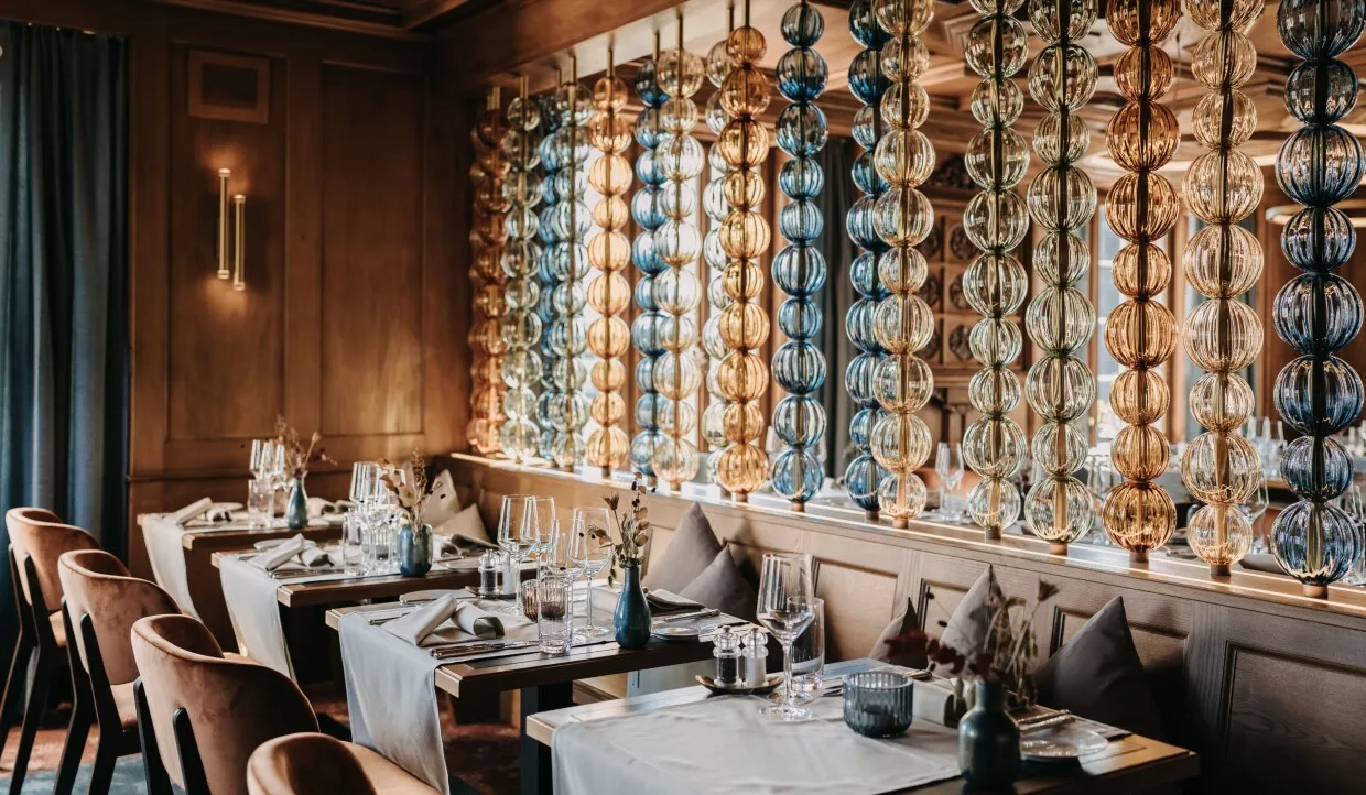 Restauranttische mit Glasketten als Dekoration im Hintergrund