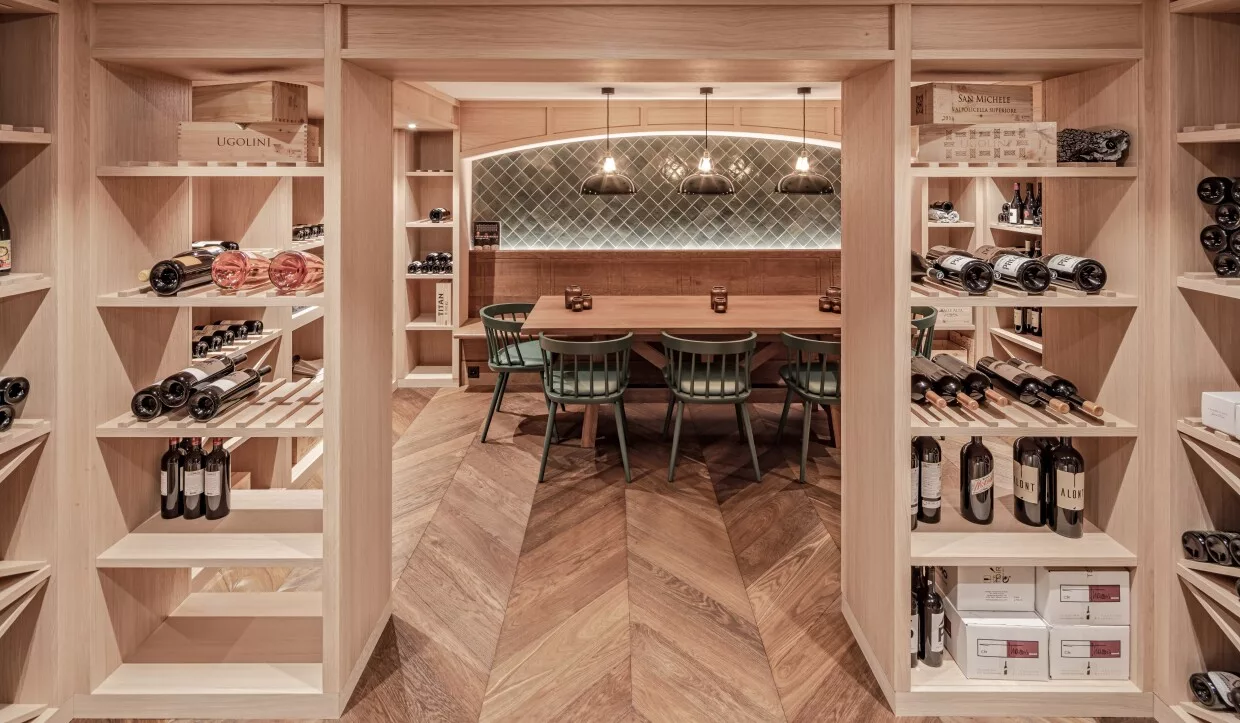 Minimalistisch-moderner Weinkeller mit Flaschenregalen und großem Holztisch