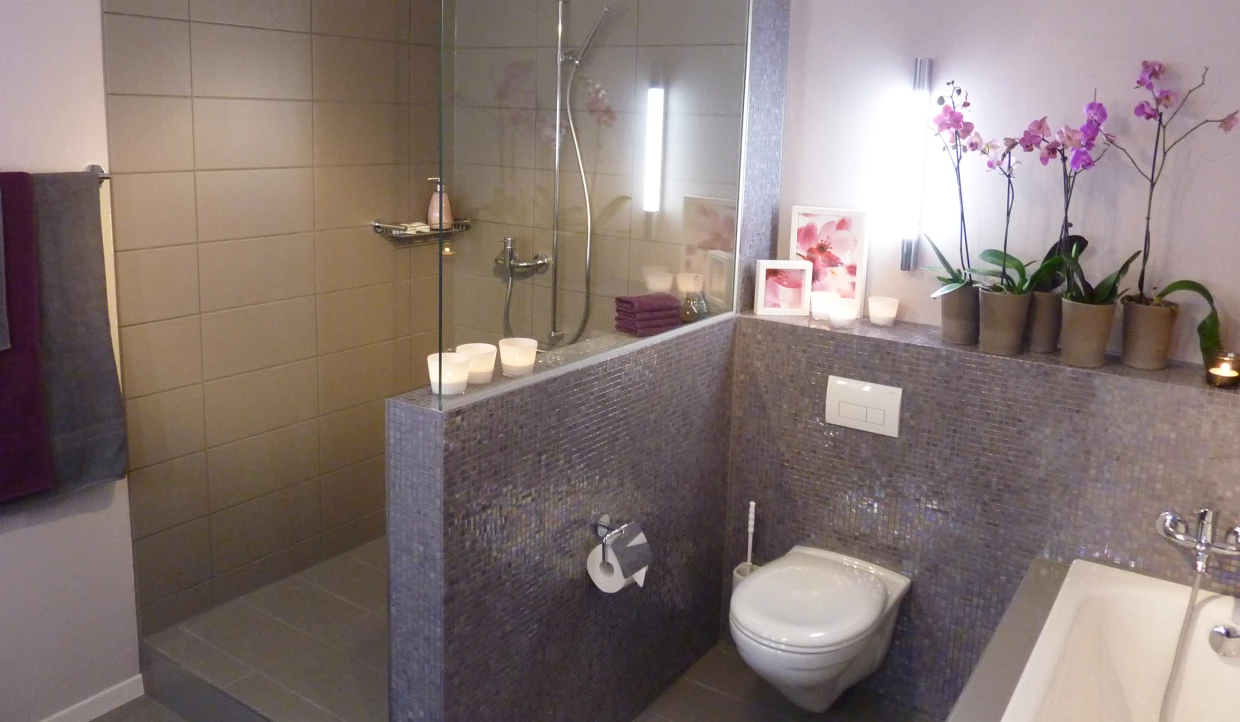 Badezimmer mit Dusche, Orchideen und Dekokerzen