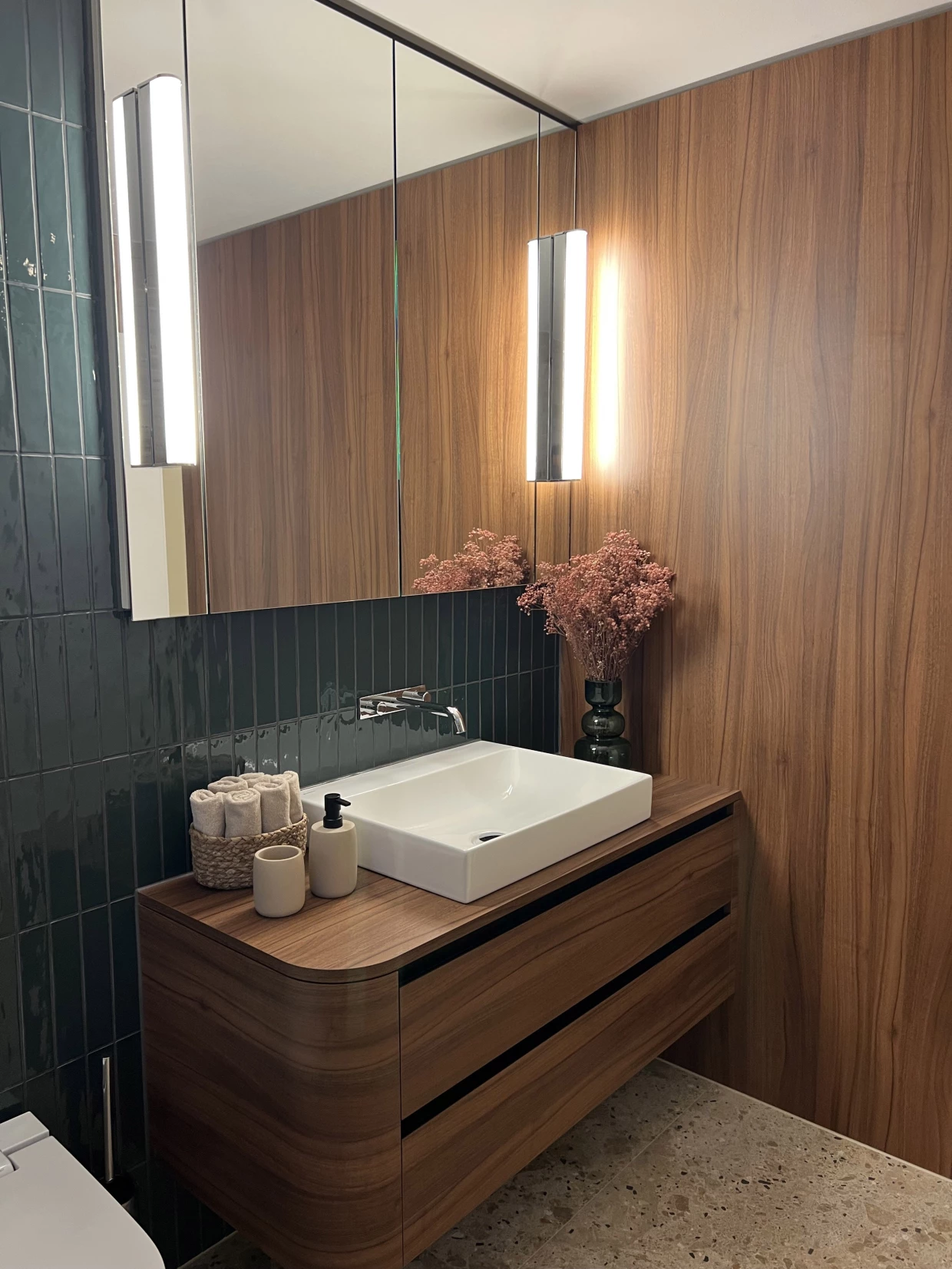 Badezimmer mit Holzmöbeln, Waschbecken und Wandspiegeln