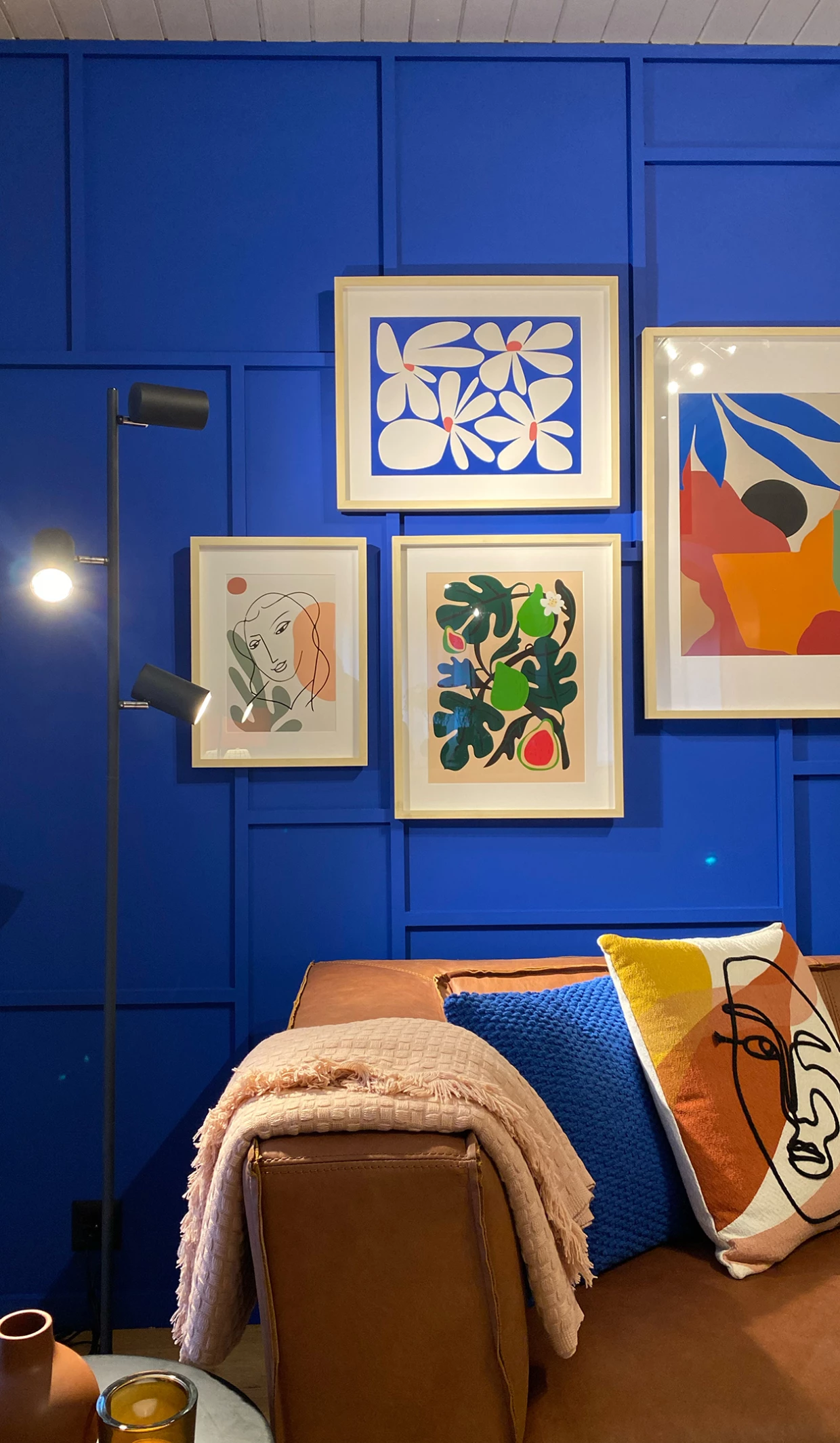 Blauer Raum mit moderner Kunst an der Wand über braunem Sofa und dekorativen Kissen