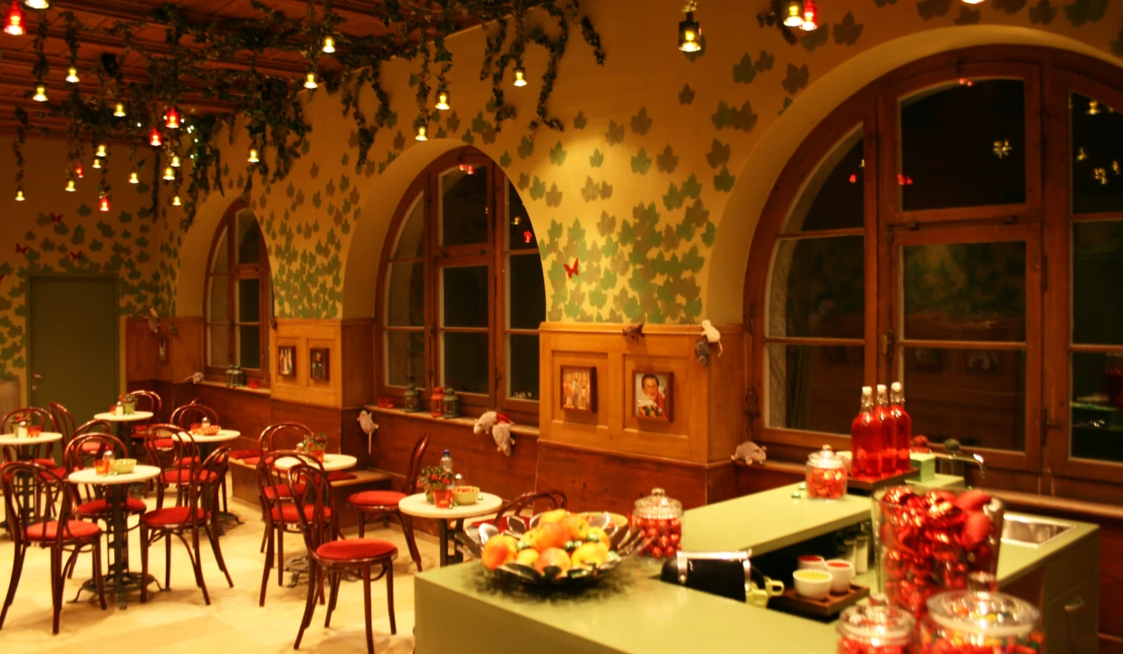 Cafe with red chairs, round tables, and leaf decor
