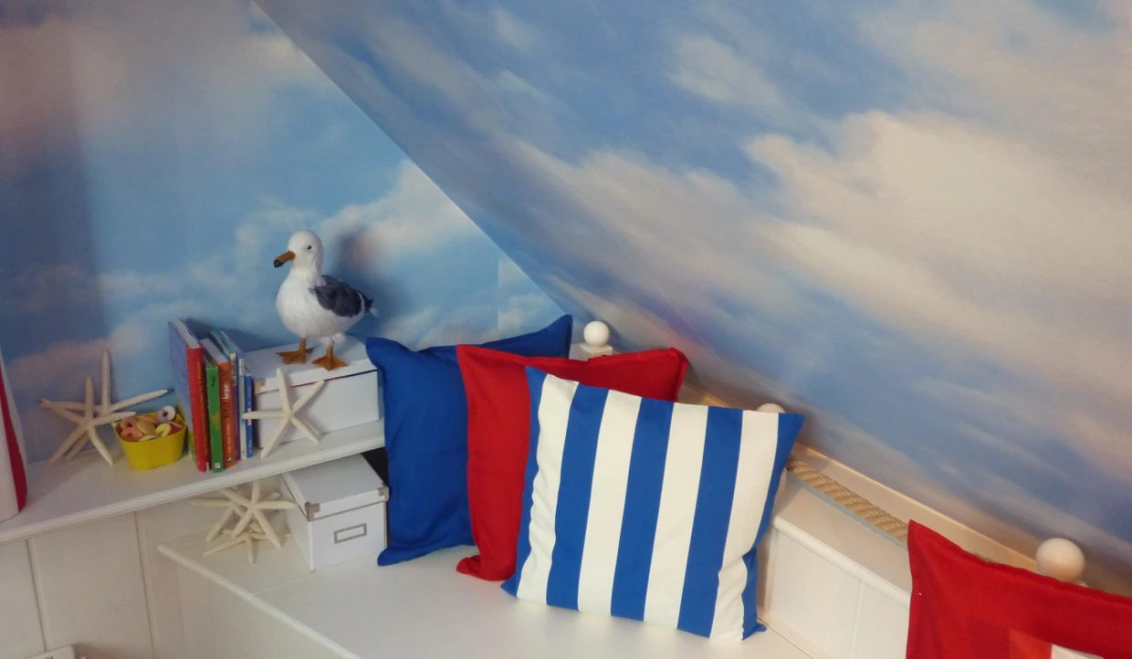 Ecke mit blauen und roten Kissen und Möwenfigur