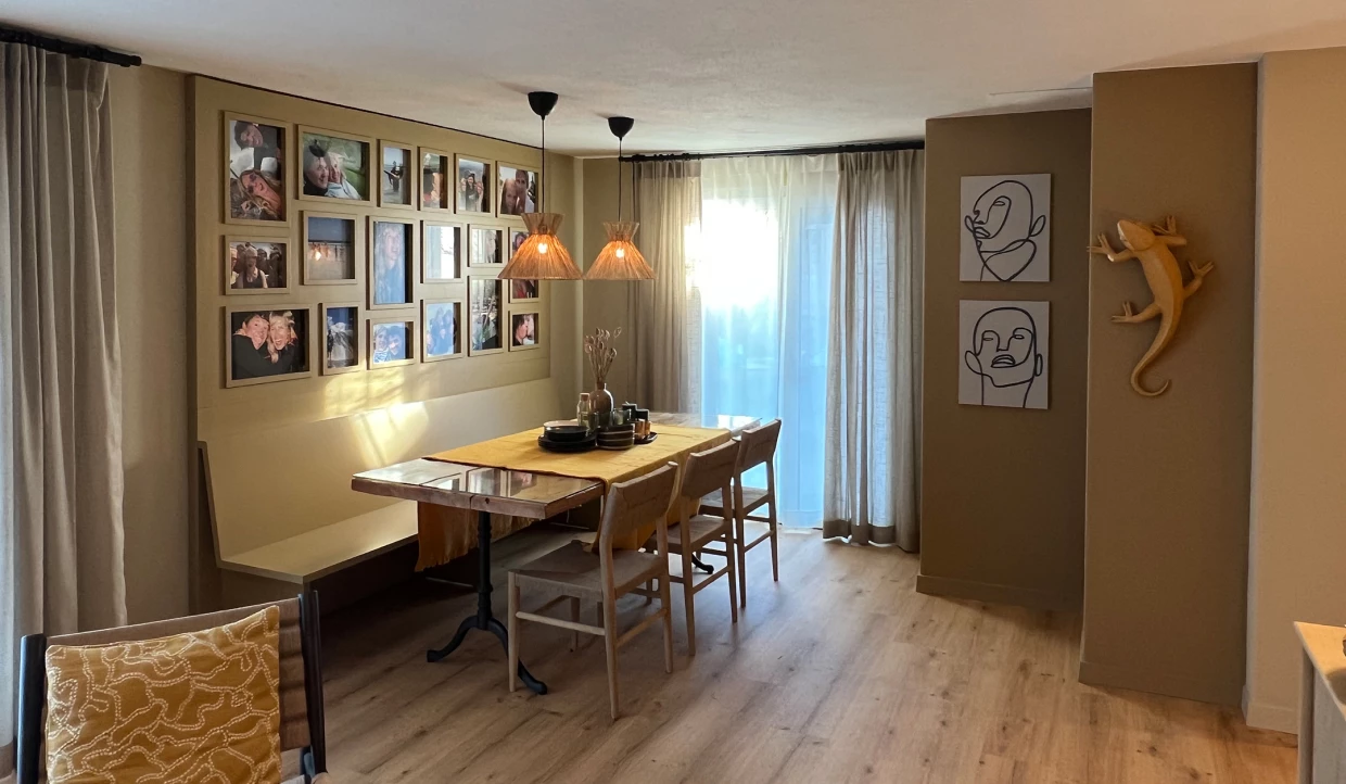 Essbereich mit Fotowand und Holzbank, Tisch mit zwei Lampen