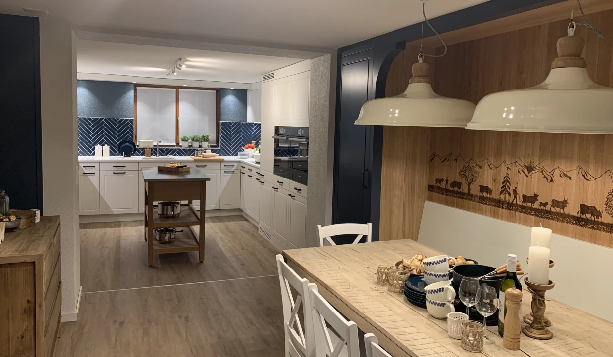 Essbereich mit Holztisch, Stühlen und Blick in die Küche