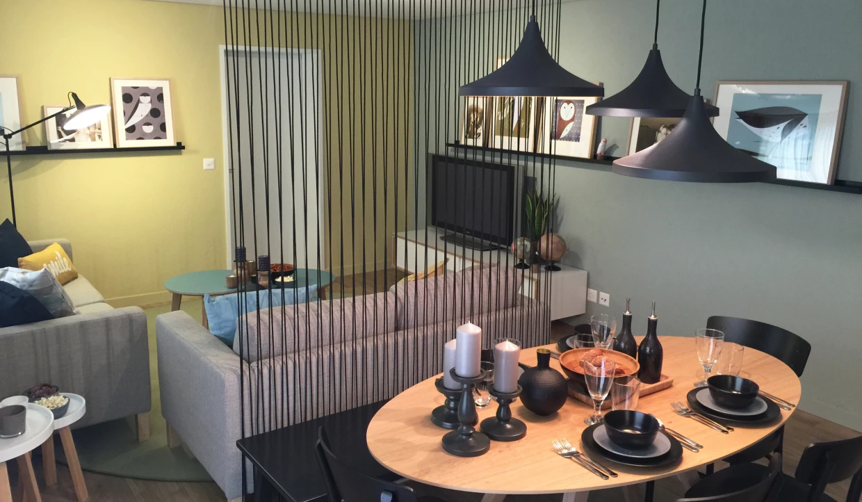 Esszimmer und Wohnzimmer mit Sofa, Hängelampen und Bildern an der Wand