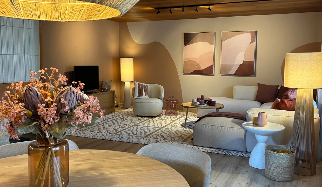 Gemütlicher Wohnraum mit Sofa, Bilderrahmen und Blumen