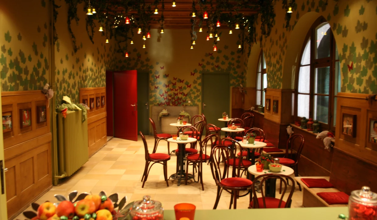Cozy cafe with red chairs and plants on the ceiling