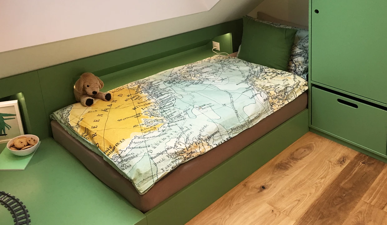 Grünes Kinderzimmer mit Bett, Landkartendecke und Plüschtier