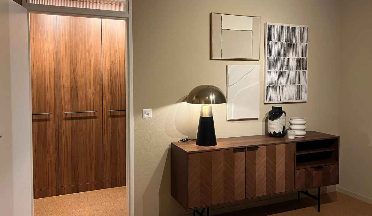Holzschrank mit dekorativer Lampe, Kunstwerken und Accessoires