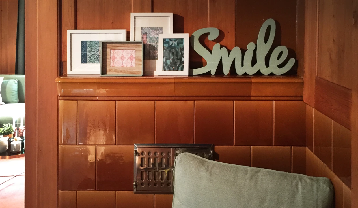Wand mit gerahmten Bildern, der Schriftzug "Smile" auf einem Regal
