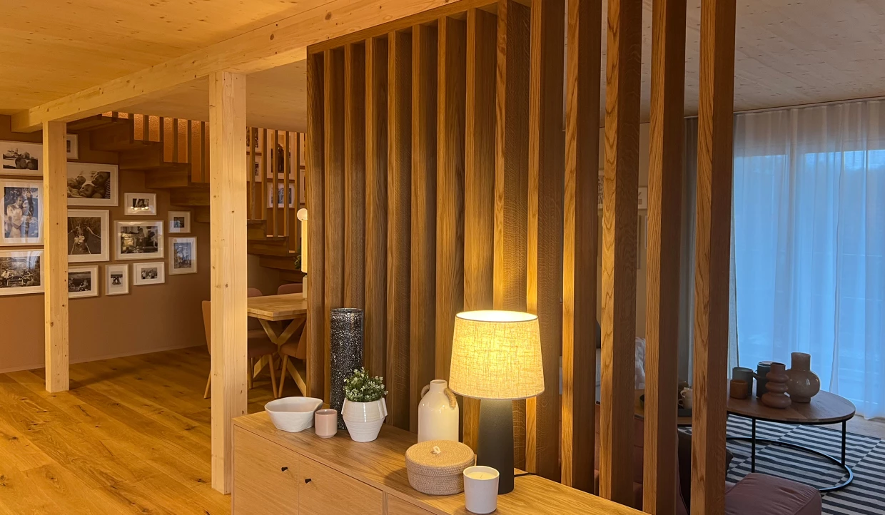 Holzwand mit Dekoobjekten, Lampe, Blick auf Treppe