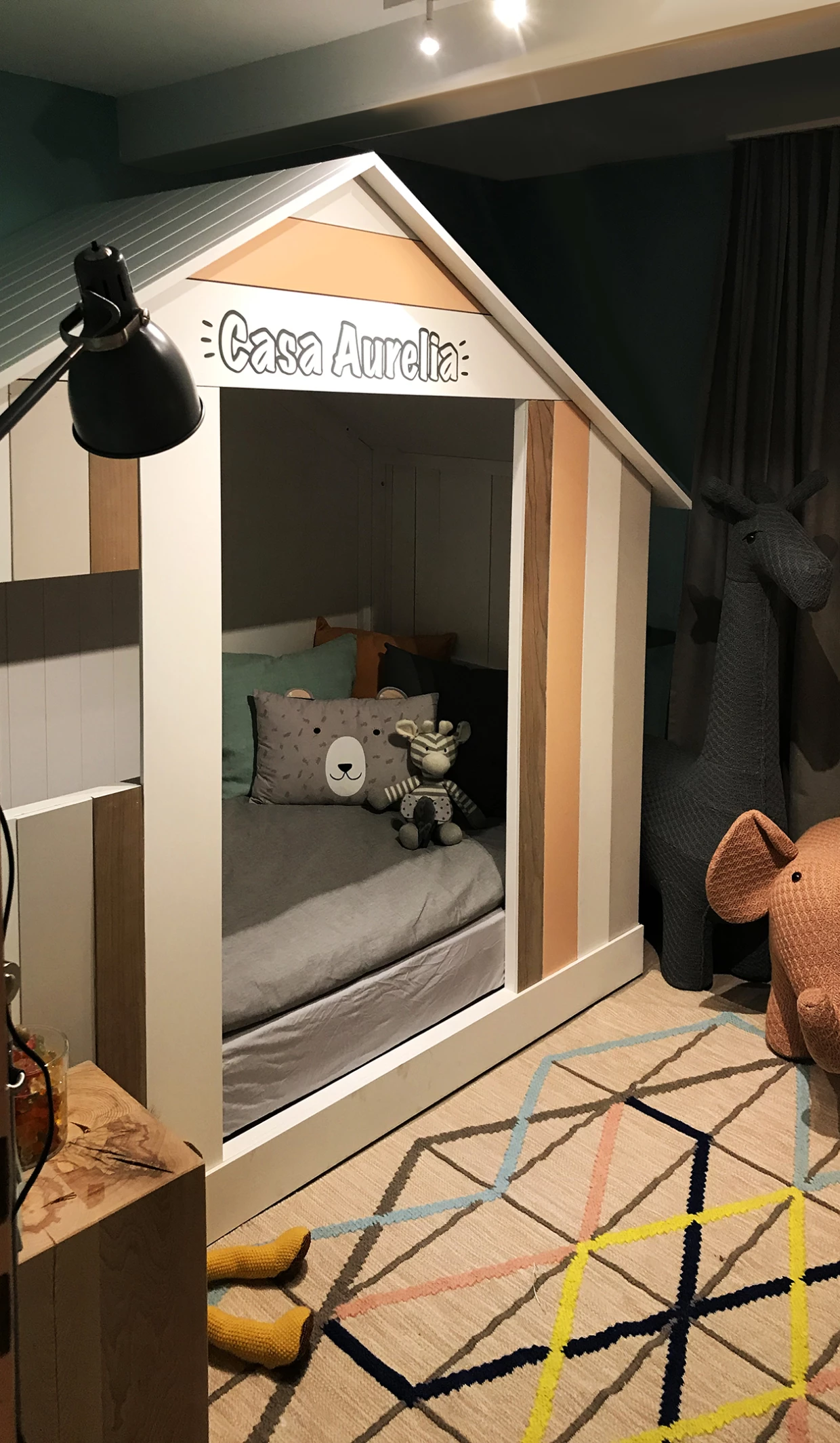Kids' bed in house design with stuffed animals