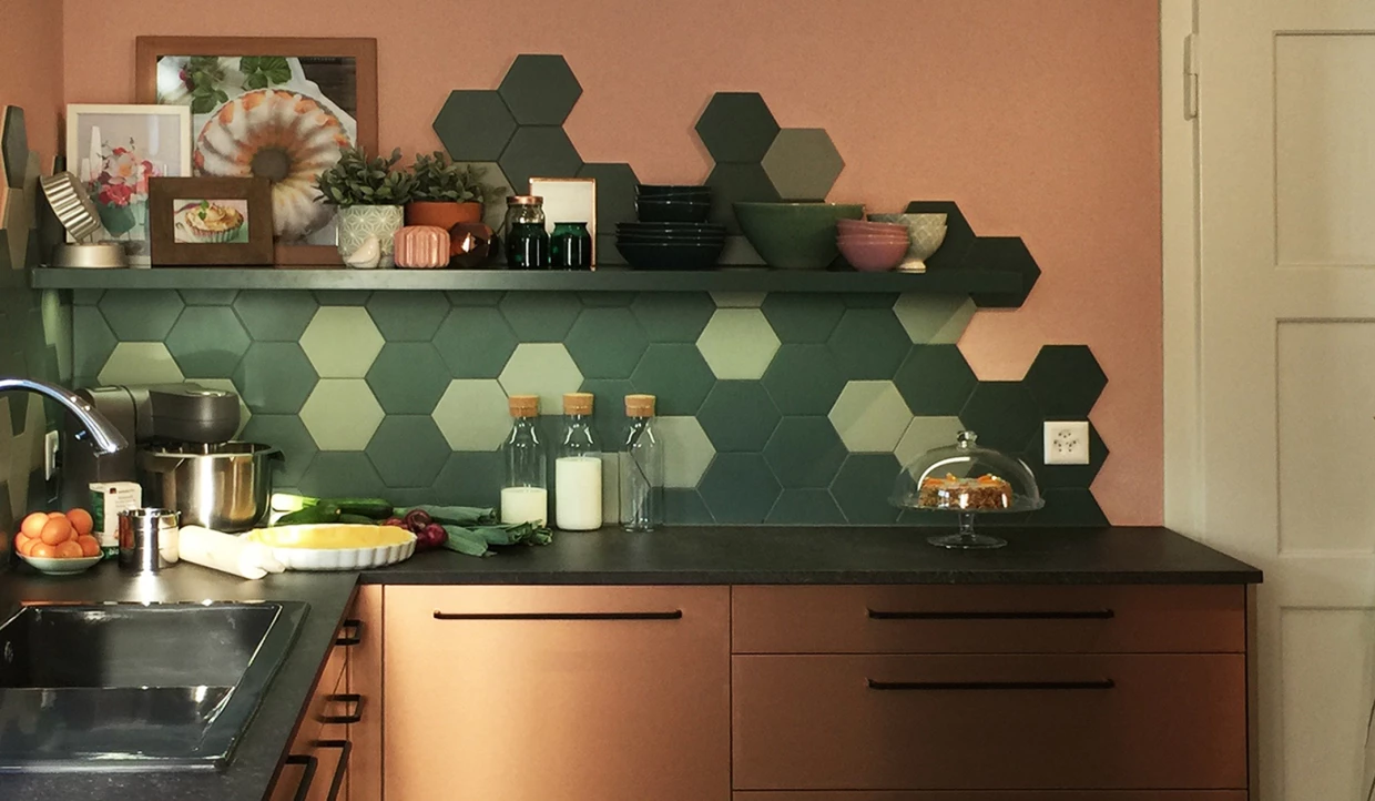 Küche mit grünen Hexagonfliesen und Küchenregal mit Geschirr