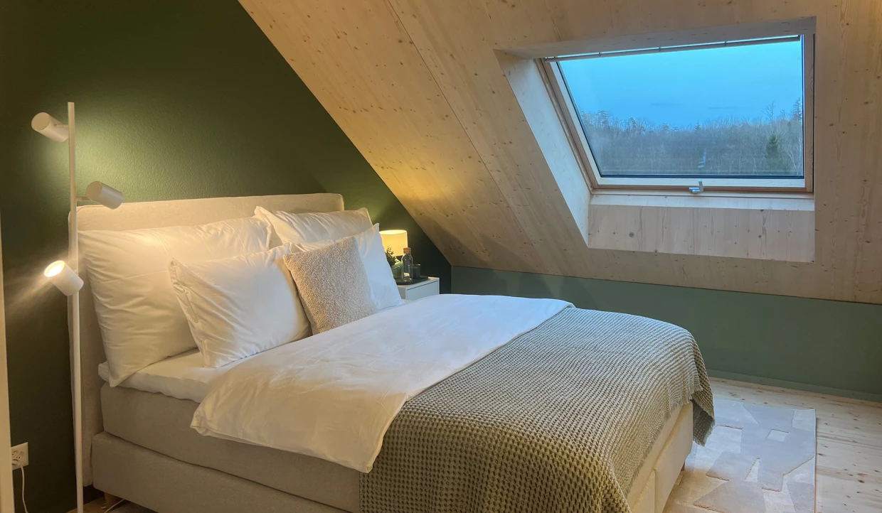 Schlafzimmer mit Dachschräge, Bett, Fenster, Lampe
