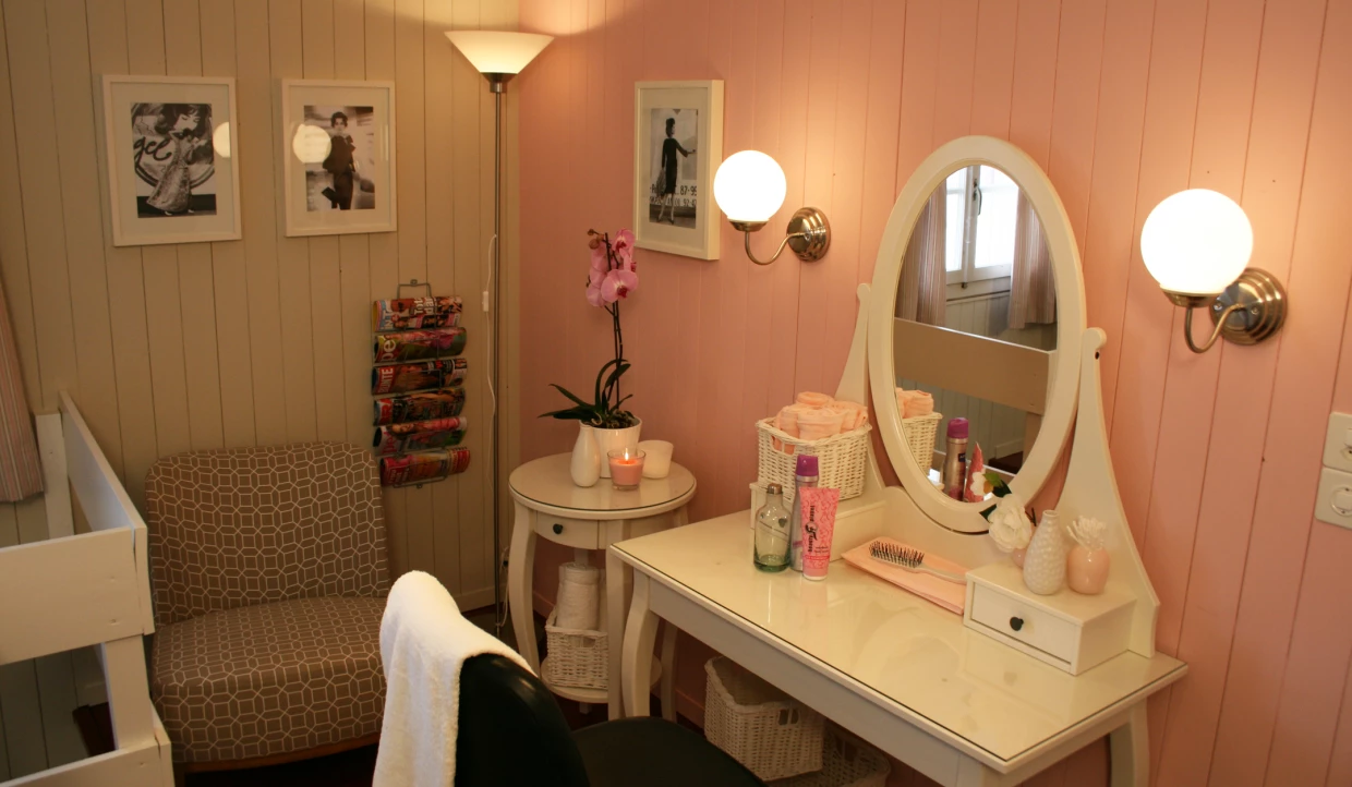 Schminktisch mit Spiegel, Lampe, Orchidee und Fotos