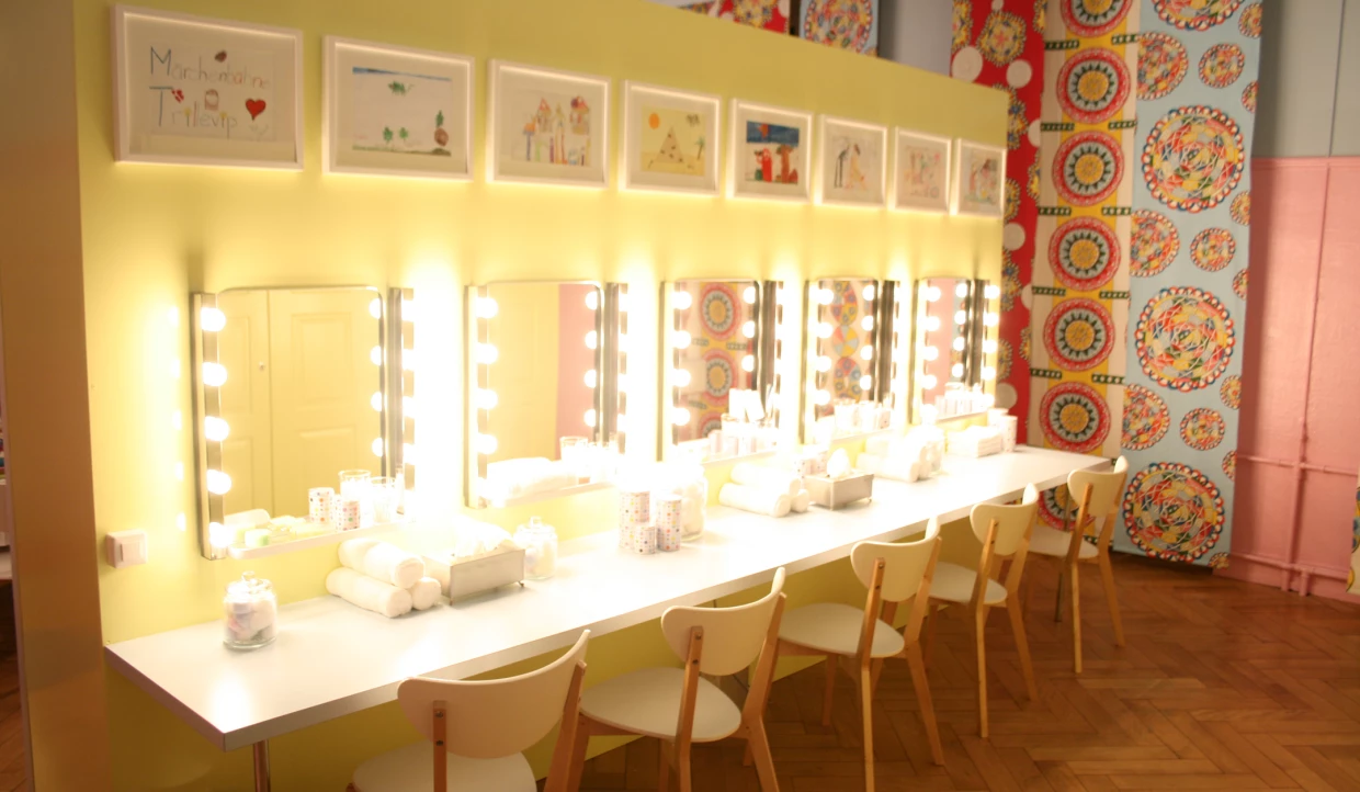 Dressing table with lit mirrors and colorful drawings
