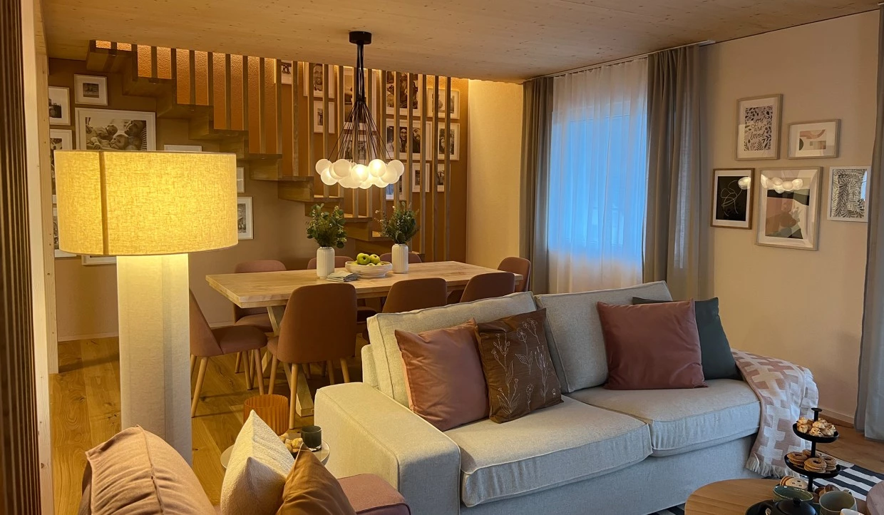 Wohnbereich mit Sofa, Esstisch, Treppenansicht