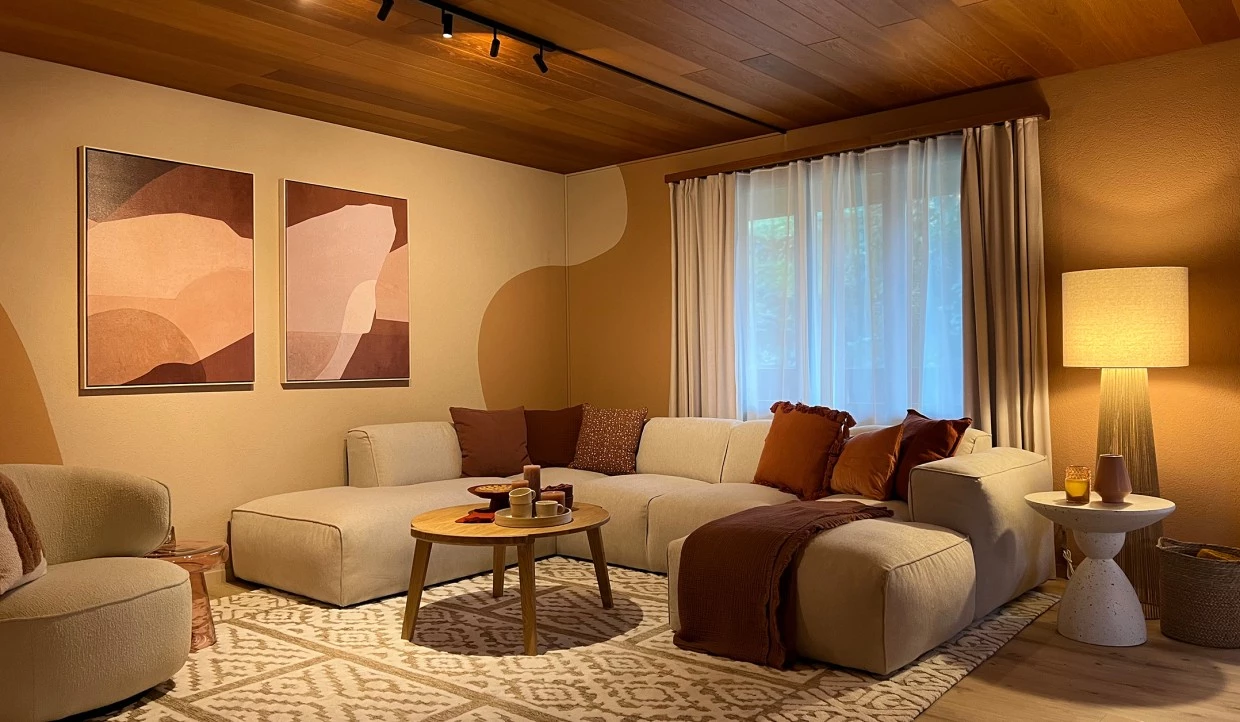 Wohnzimmer mit beigem Sofa, Tisch und Fenster