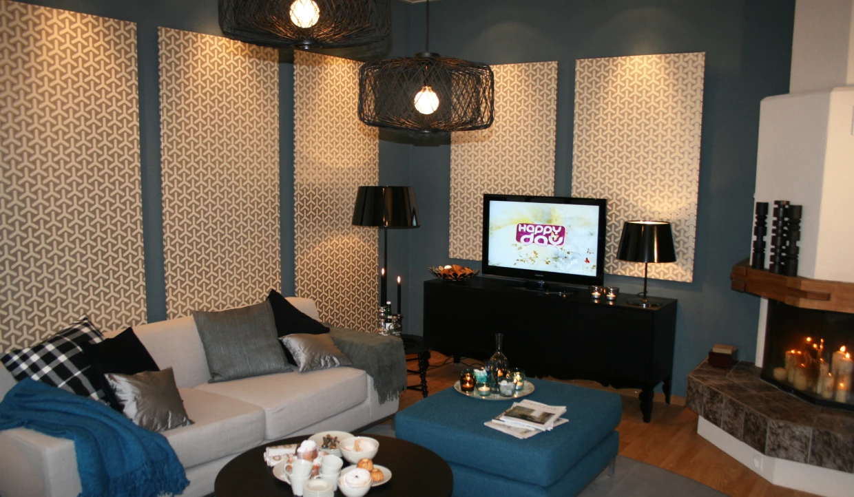 Wohnzimmer mit Sofa, TV, und gemusterten Wänden