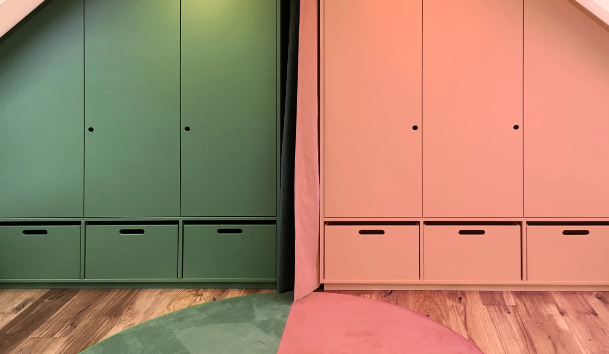 Zwei Schränke, einer grün, einer rosa, in einem Zimmer